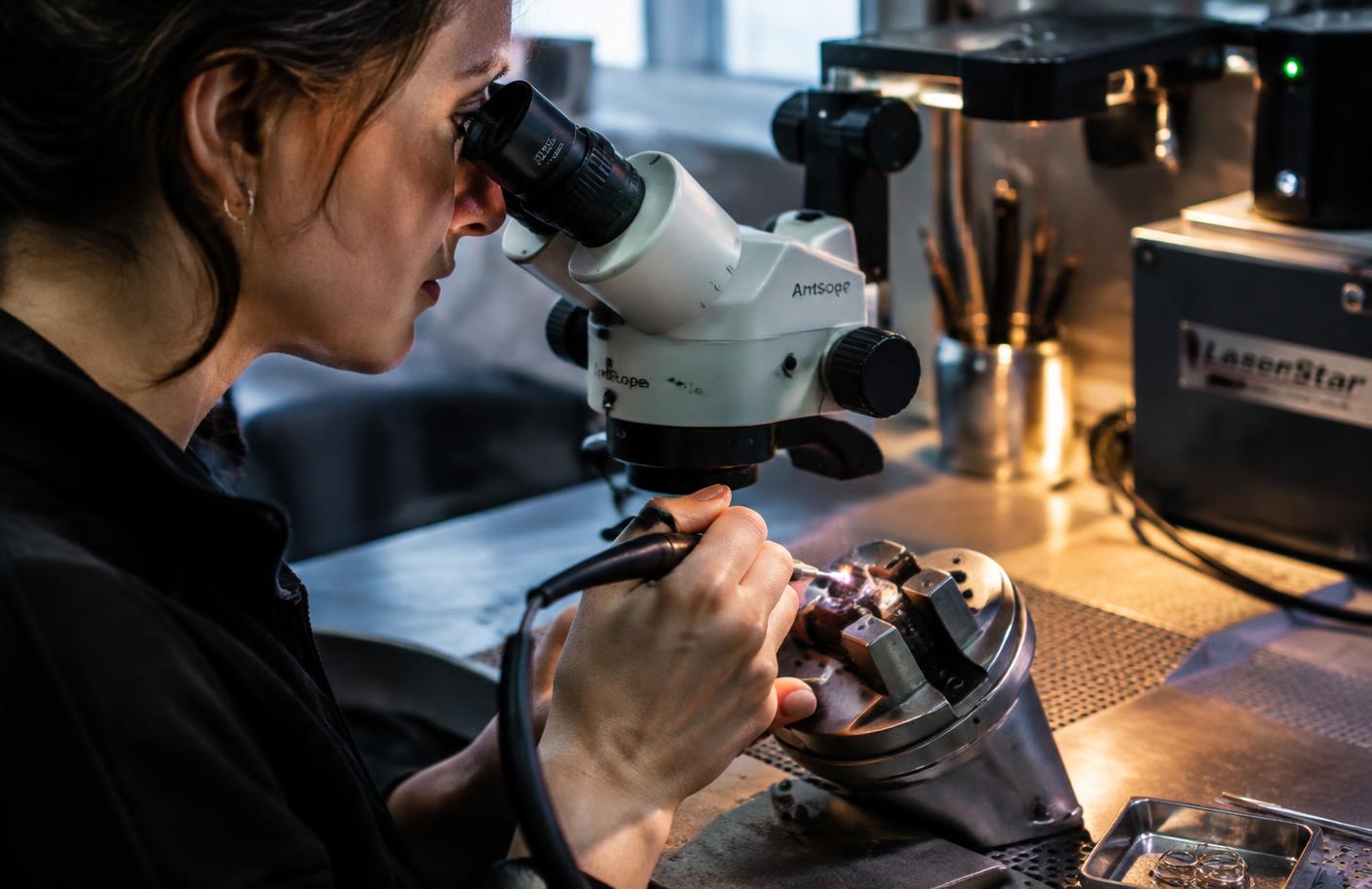 Jeweler repairing a gold ring at the bench